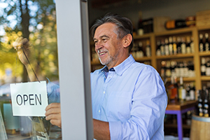 Wine shop owner holding open sign