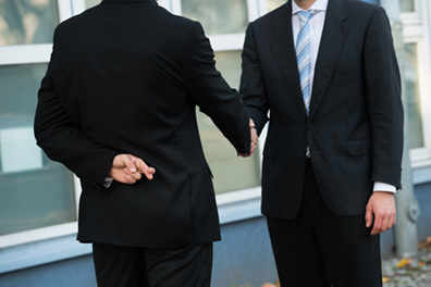 investor with fingers crossed shaking hands with current broker or advisor